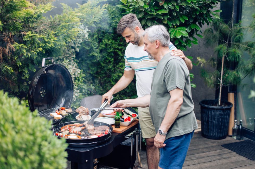 Father and son grilling outside.